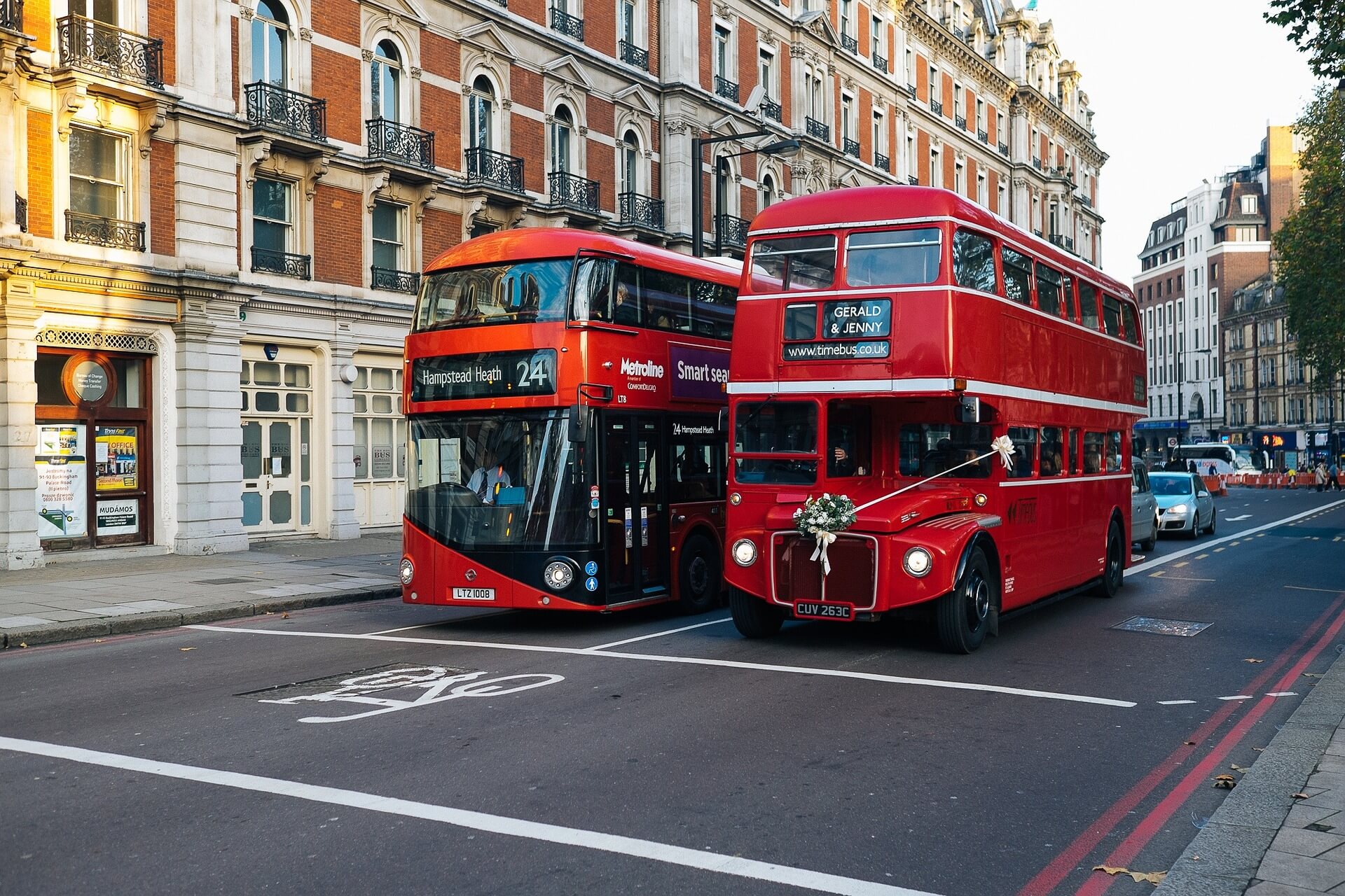 Zwei rote Doppeldecker auf einer londoner Straße