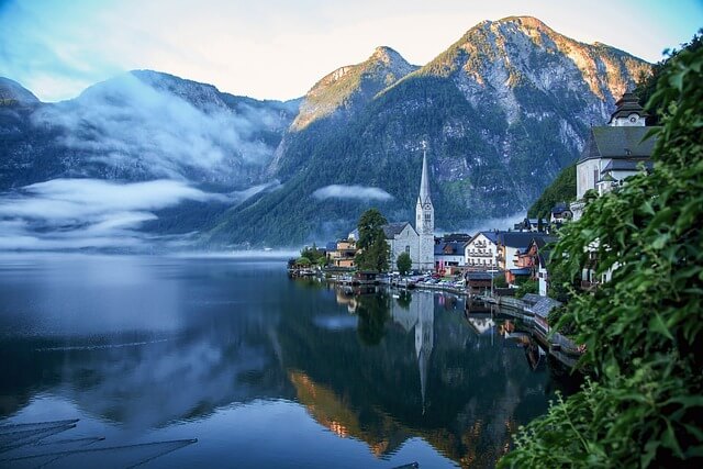 Hallstatt im Nebel mit Blick auf den See und eine malerische Kirche